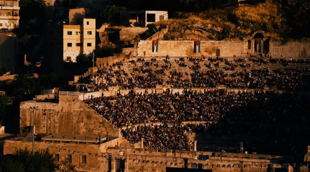 A bustling Roman Theatre in Amman, Jordan, filled with people during sunset, showcasing local culture.